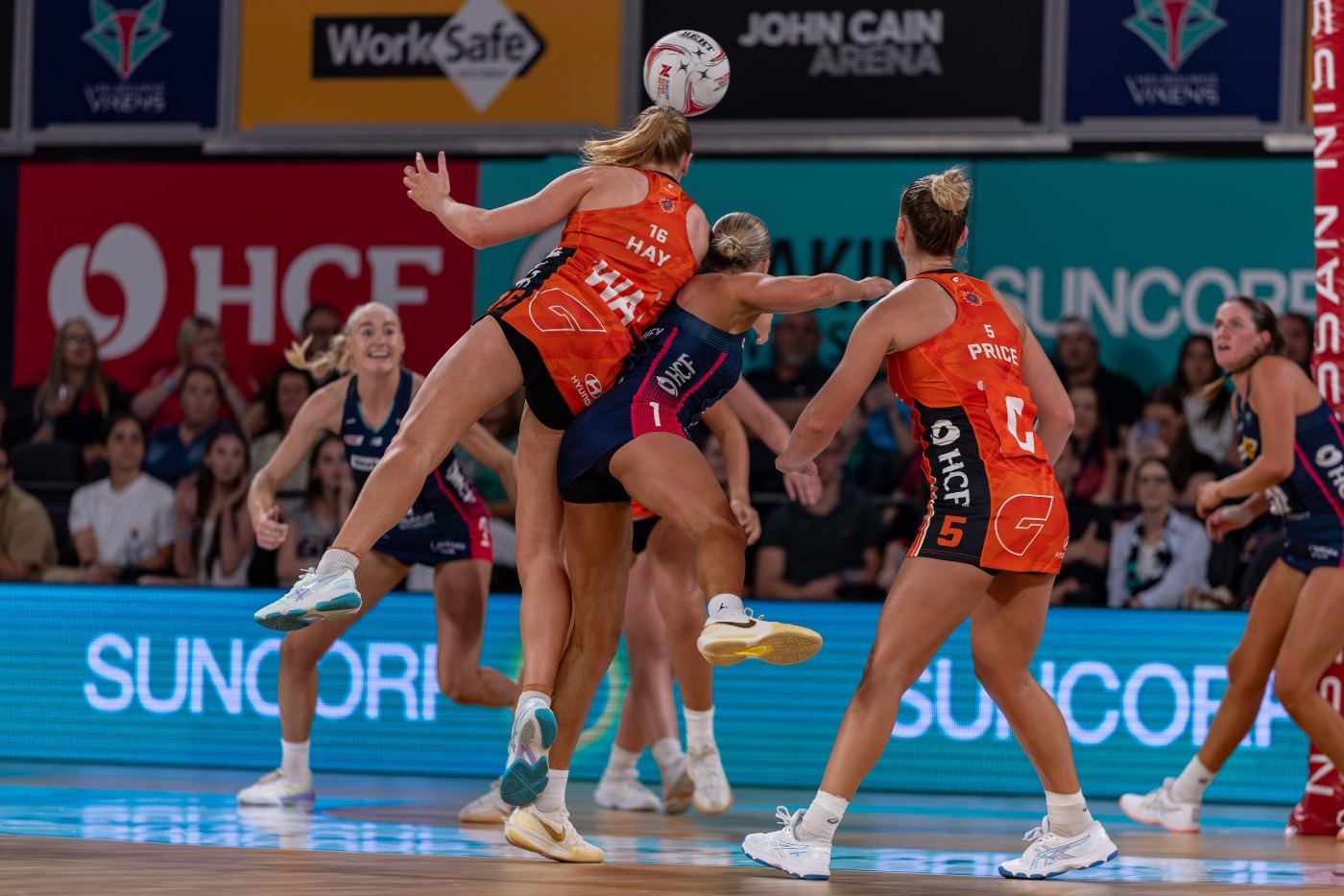 Players collide in an aerial contest during a Super Netball match