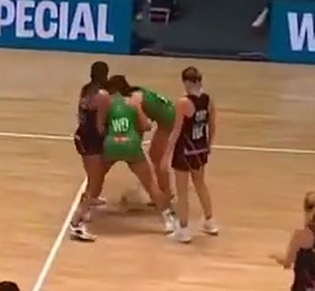 Zoomed view of the two attacking players at the moment of the pass, their shoulders and arms blocking the space around the ball